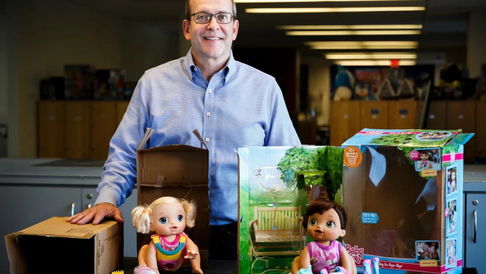 Jeff Jackson de Hasbro muestra la diferencia entre el embalaje estándar minorista (a la derecha) y el embalaje mínimo y reciclable diseñado para la compra en línea.